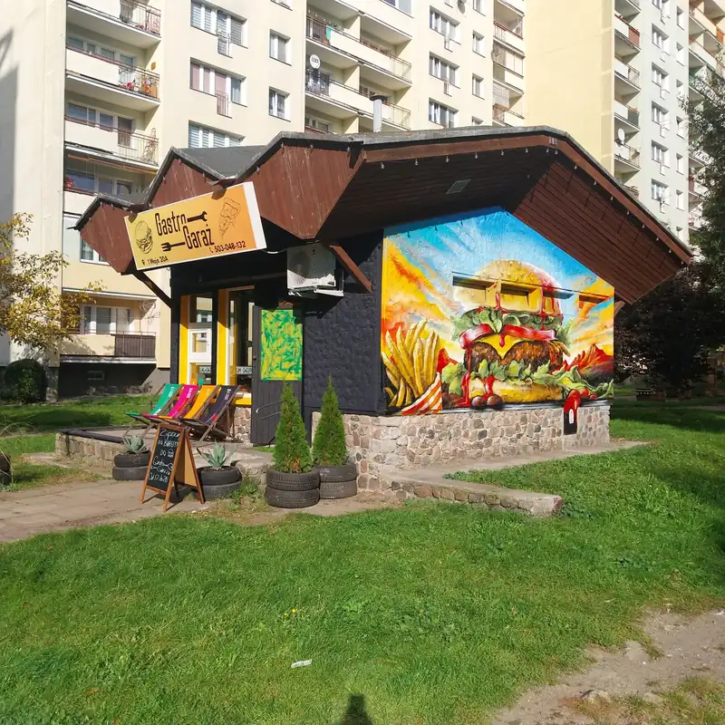 Drewniany pawilon Gastro Garaż z kolorowym muralem na ścianie